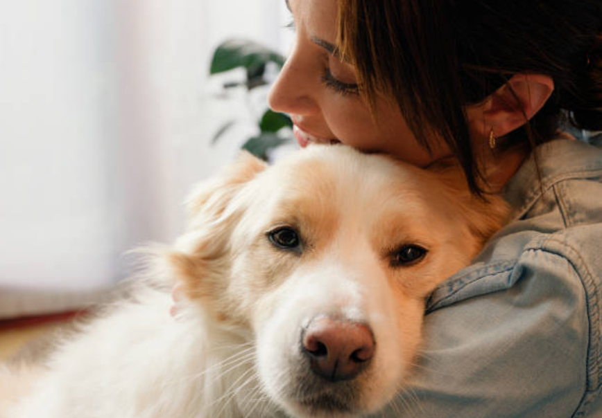A woman holding a golden dog close to her face